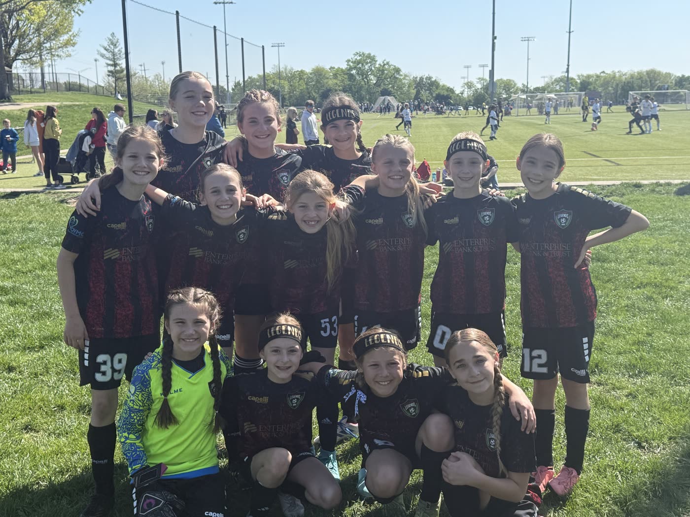A St. Louis Legends team in black kits poses together at the field