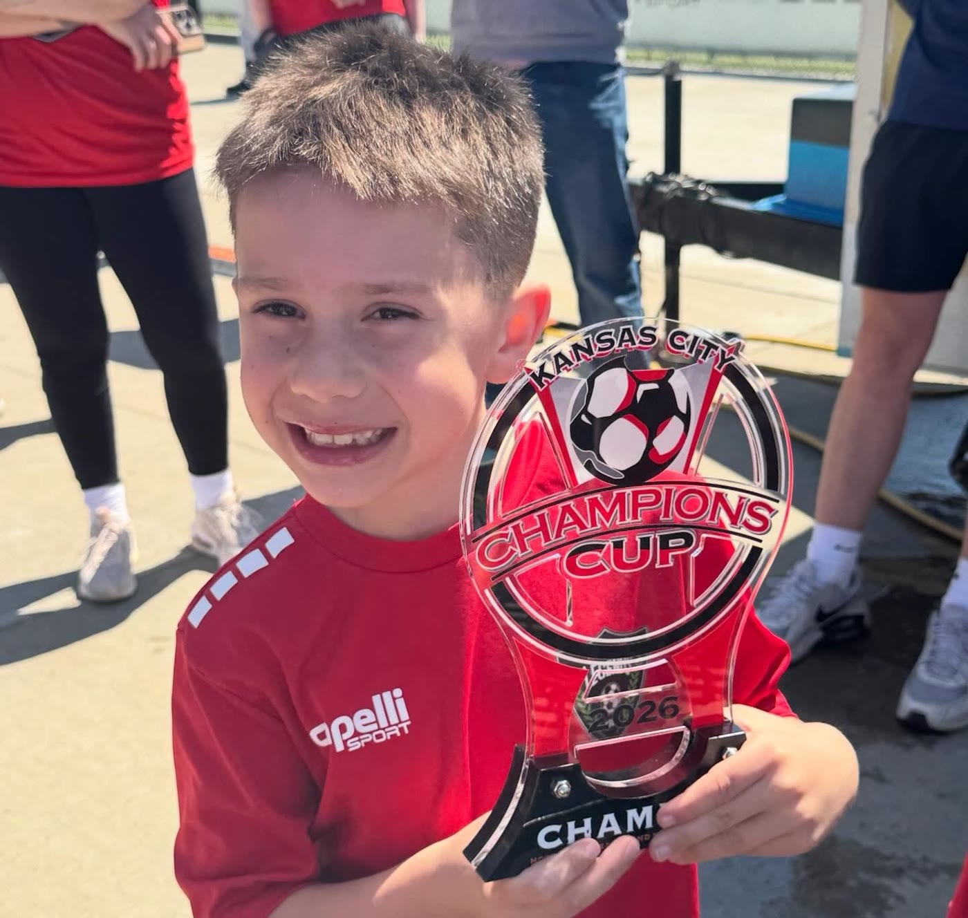 A St. Louis Legends player holding a Kansas City Champions Cup trophy