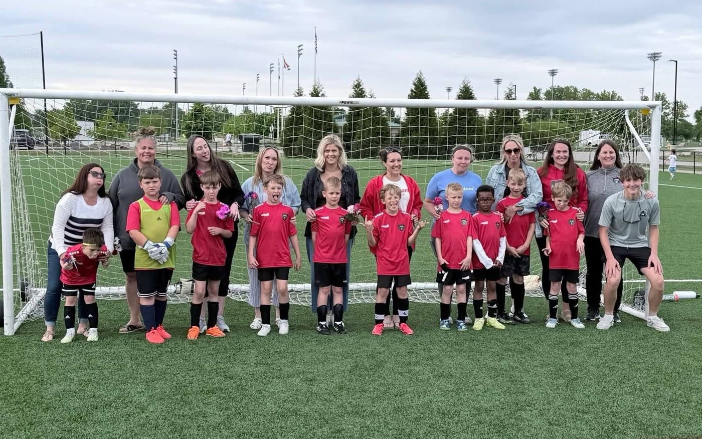 A St. Louis Legends Mother’s Day team photo with players, families, Coach Tricia, and Coach Jacob on the far right