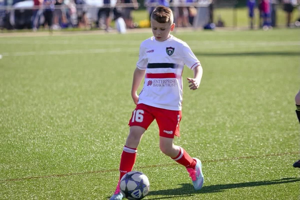 A St. Louis Legends player in a white and red kit dribbling the ball during a match